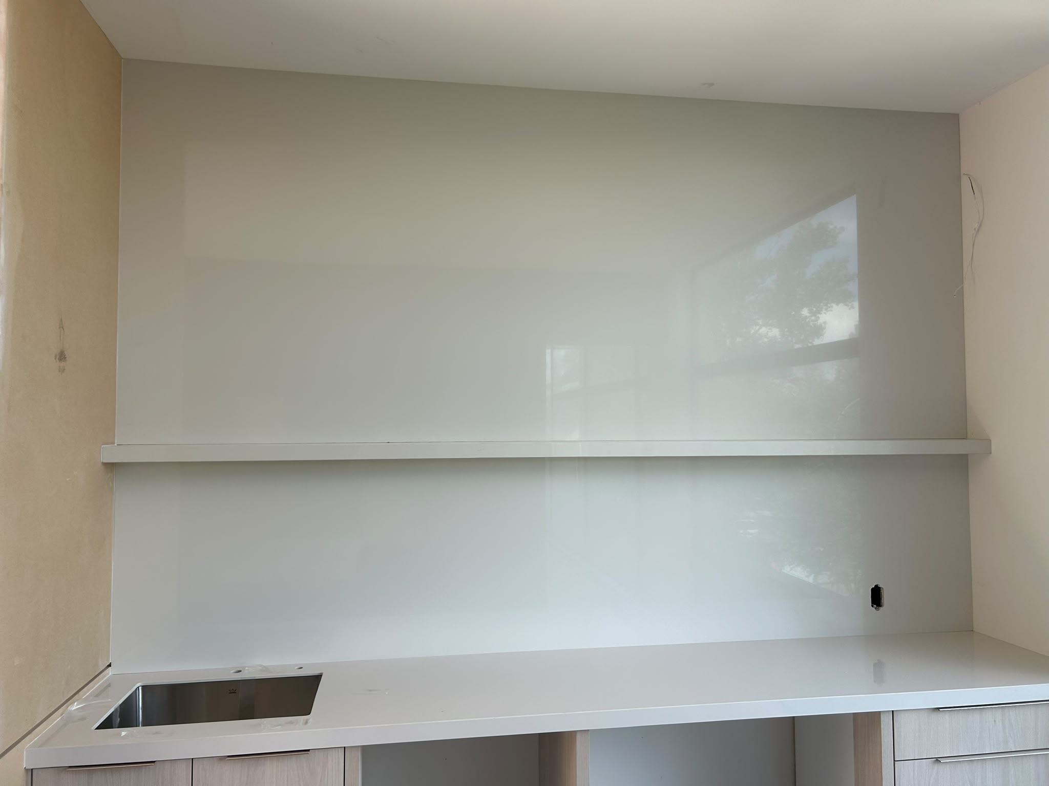 White stone backsplash with floating shelf
